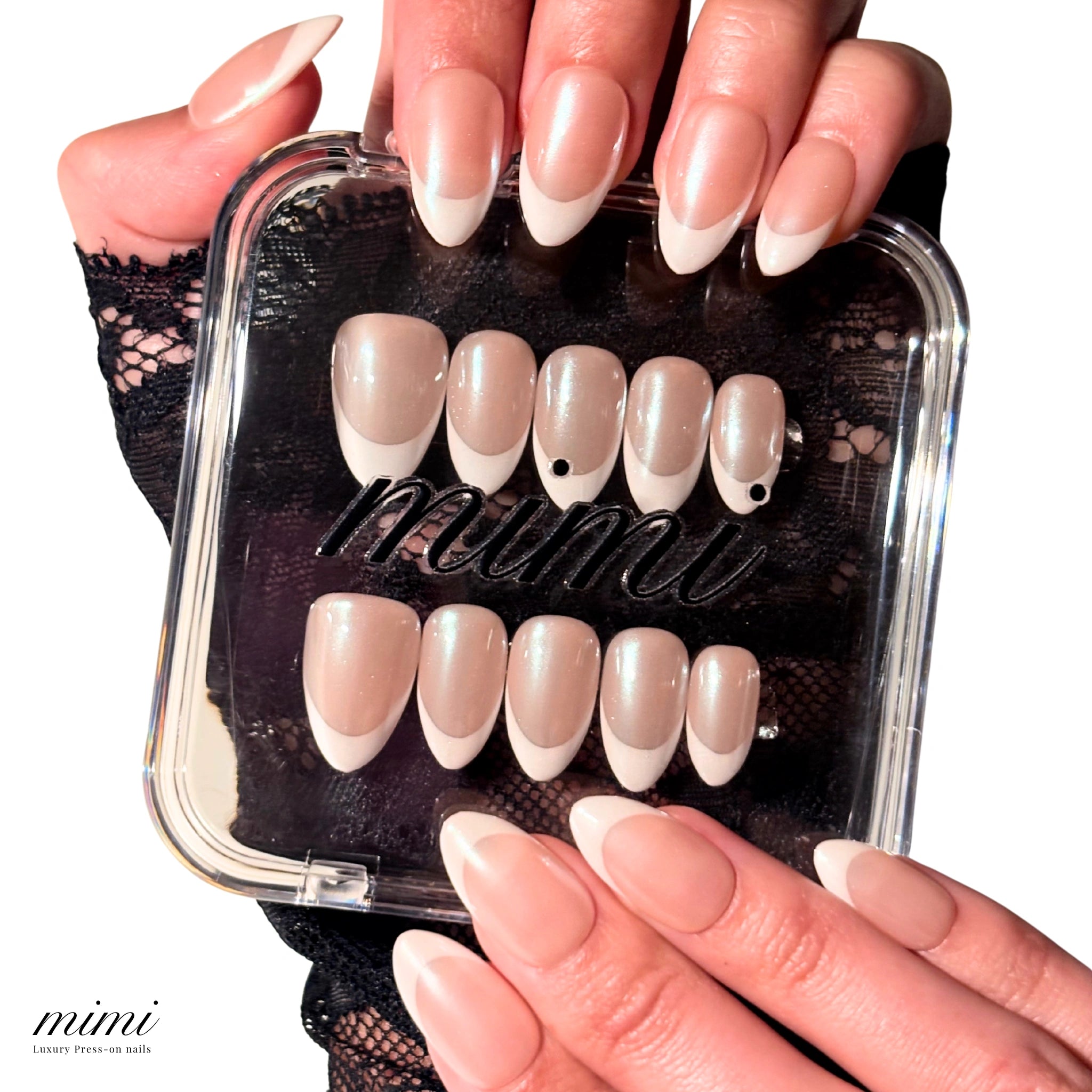 Coffret transparent Mimi contenant les press-on Silky French faits main, gel et acrylique, accompagné d’une main portant la french amande finition nacrée.