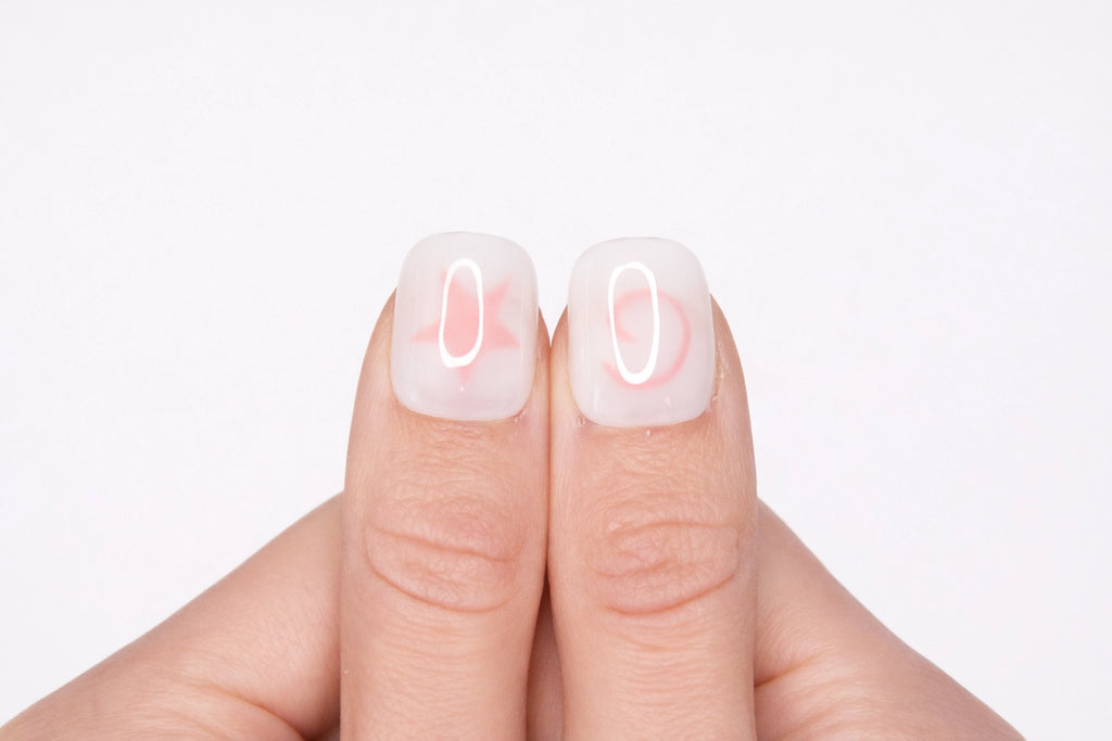 Gros plan sur le pouce avec faux ongle press-on blanc motif étoile rose — design Pink Dream fait main — Mimi Press-On