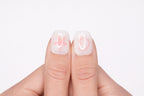 Gros plan sur le pouce avec faux ongle press-on blanc motif étoile rose — design Pink Dream fait main — Mimi Press-On