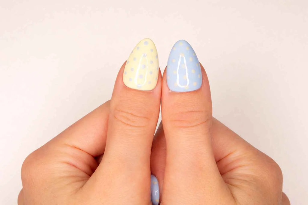 Gros plan sur le pouce avec faux ongle press-on bicolore rose et bleu à pois — design pastel fait main — Mimi Press-On