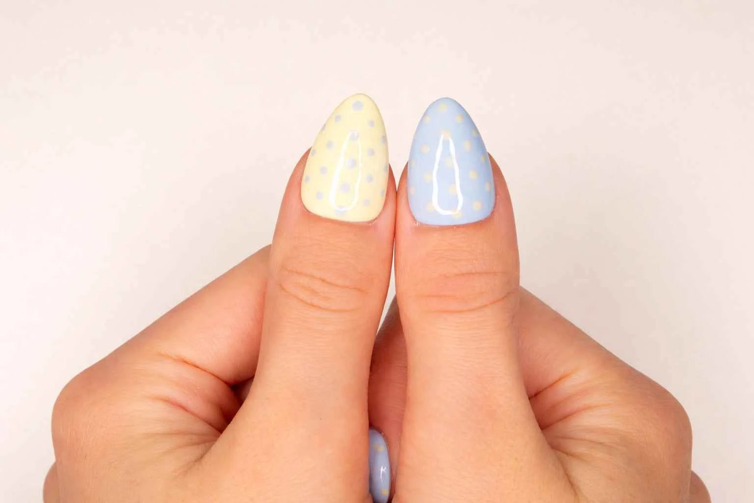 Gros plan sur le pouce avec faux ongle press-on bicolore rose et bleu à pois — design pastel fait main — Mimi Press-On