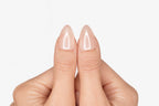 Gros plan sur le pouce avec faux ongle press-on rose pâle nacré effet glazed — design Hailey fait main — Mimi Press-On