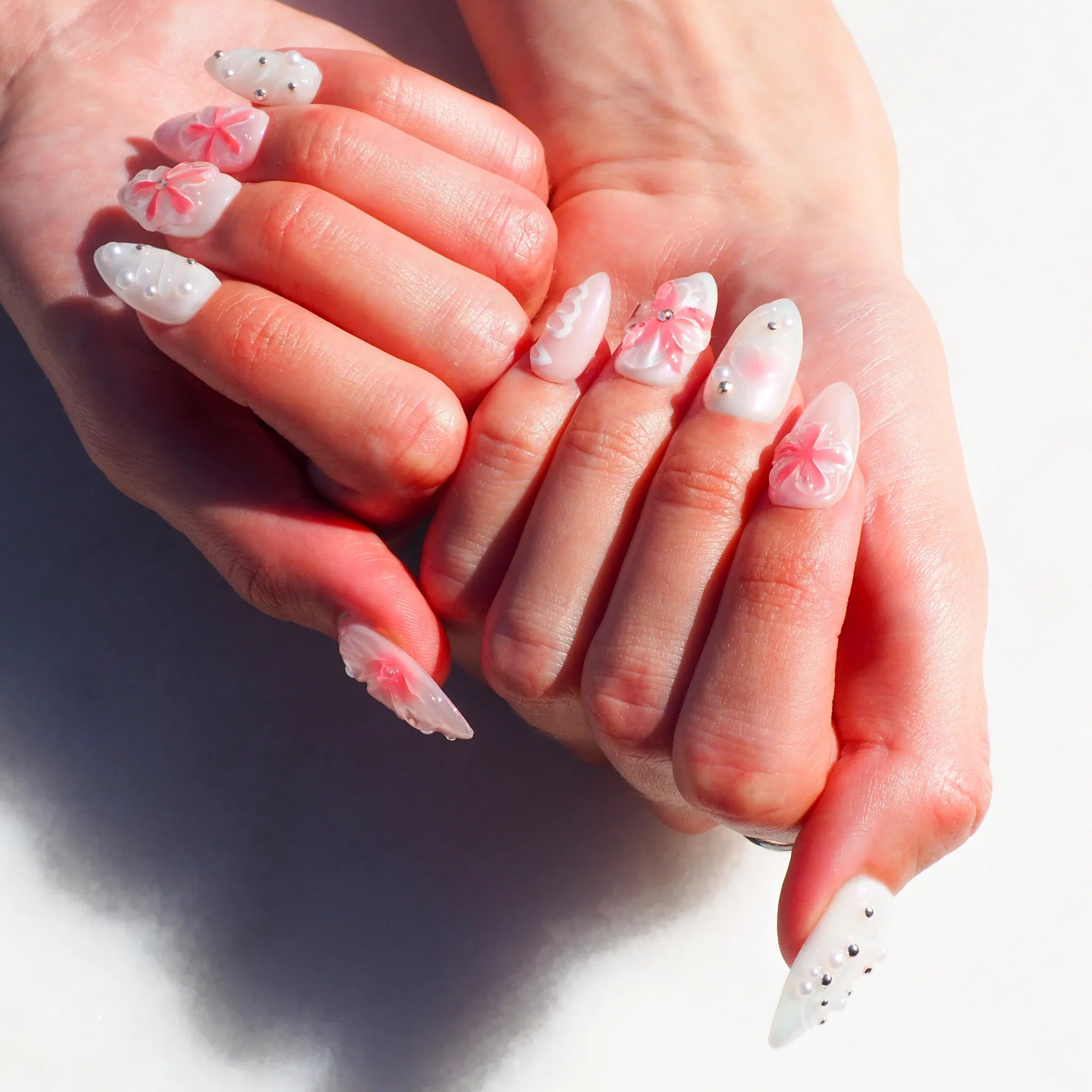 Press-on nails Pink Fever en rose pastel et blanc, fleurs 3D sculptées et détails perlés, modèle artisanal Mimi Press-on.