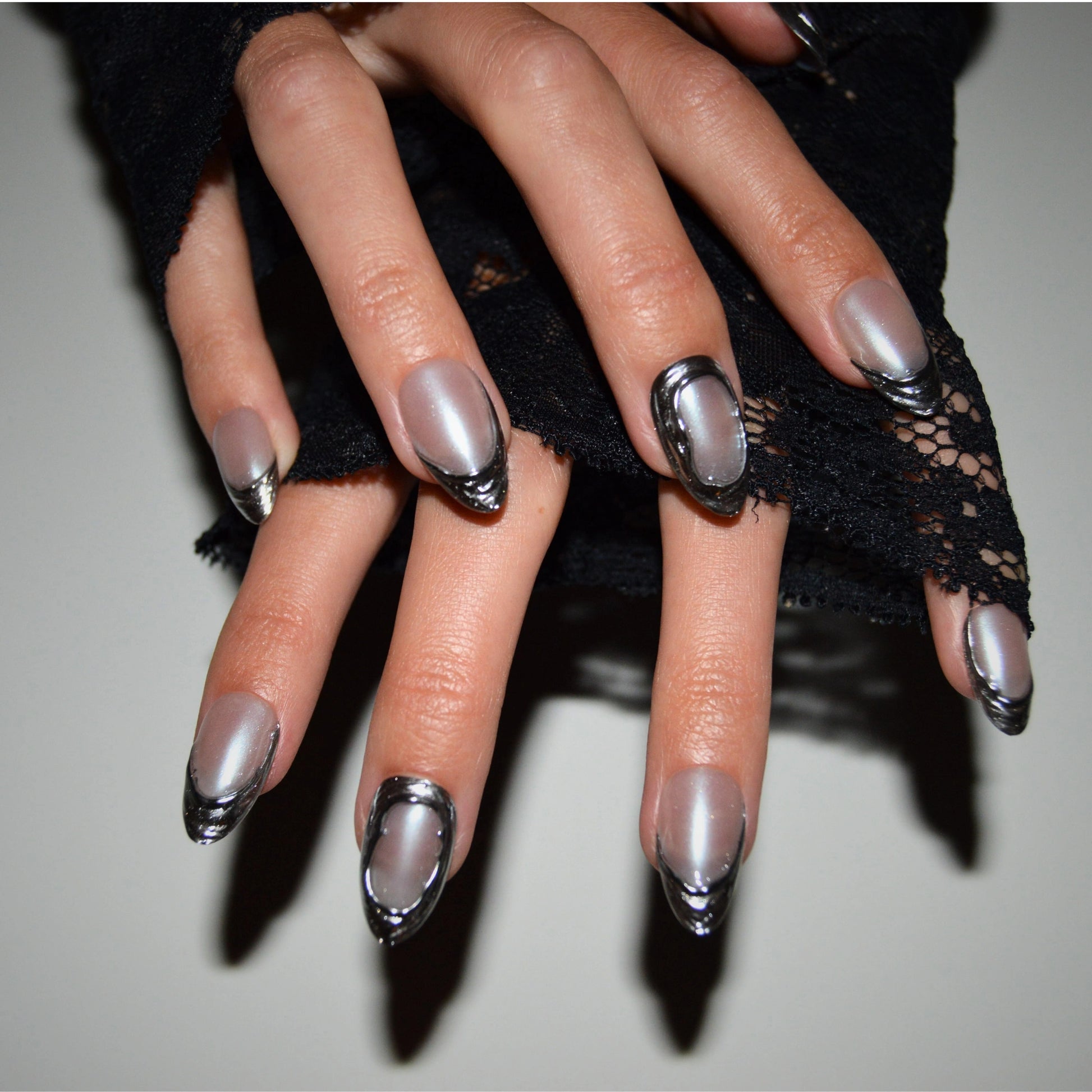 Main avec press-on nails argentés 3D, gel et acrylique, design métallisé Mimi.