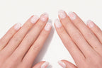Faux ongles press-on Pink Dream portés sur la main — étoiles roses et pois blancs sur base blanche et rose pâle — Mimi Press-On