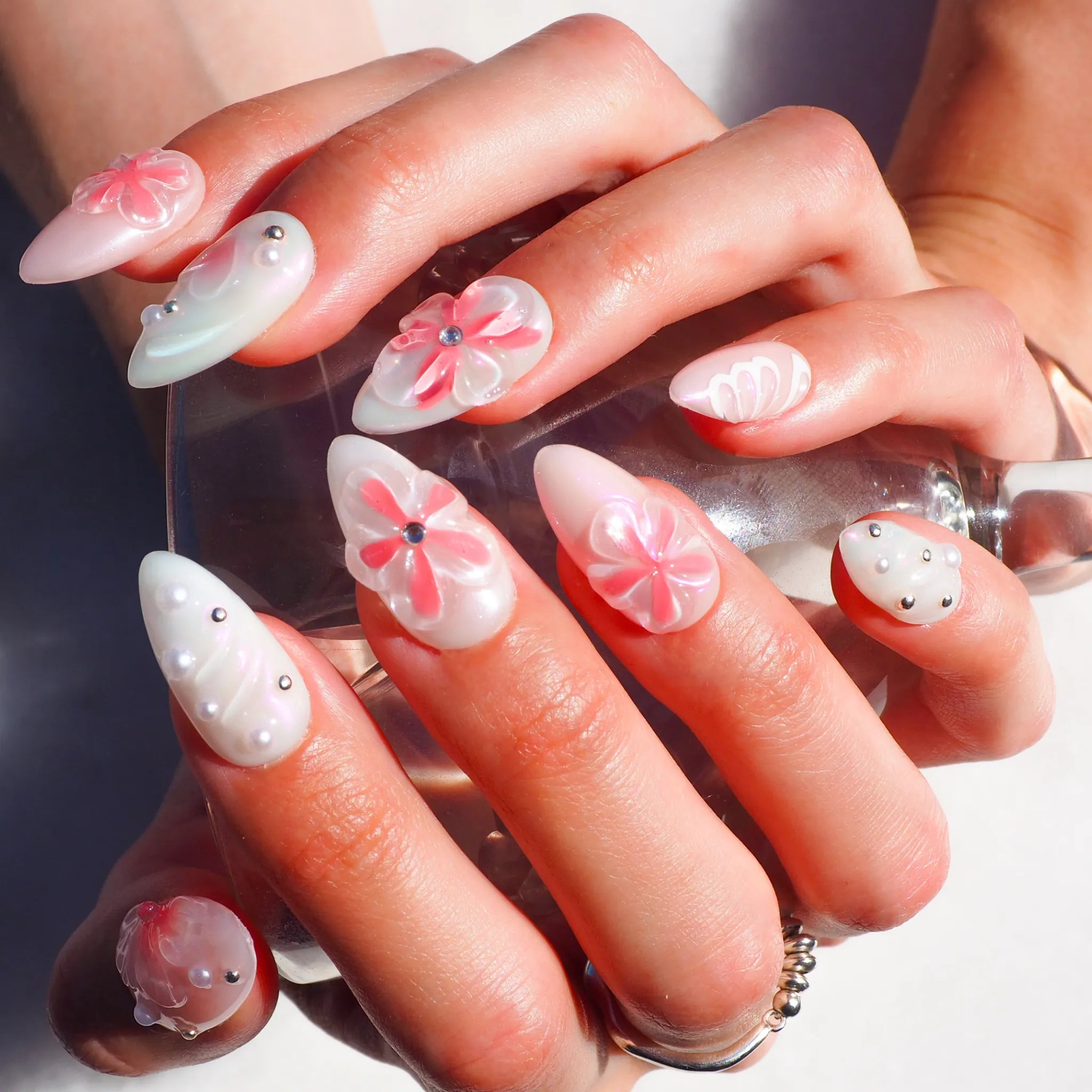Set complet de press-on nails Pink Fever en gel et acrylique, décor floral 3D rose et blanc avec détails métalliques.
