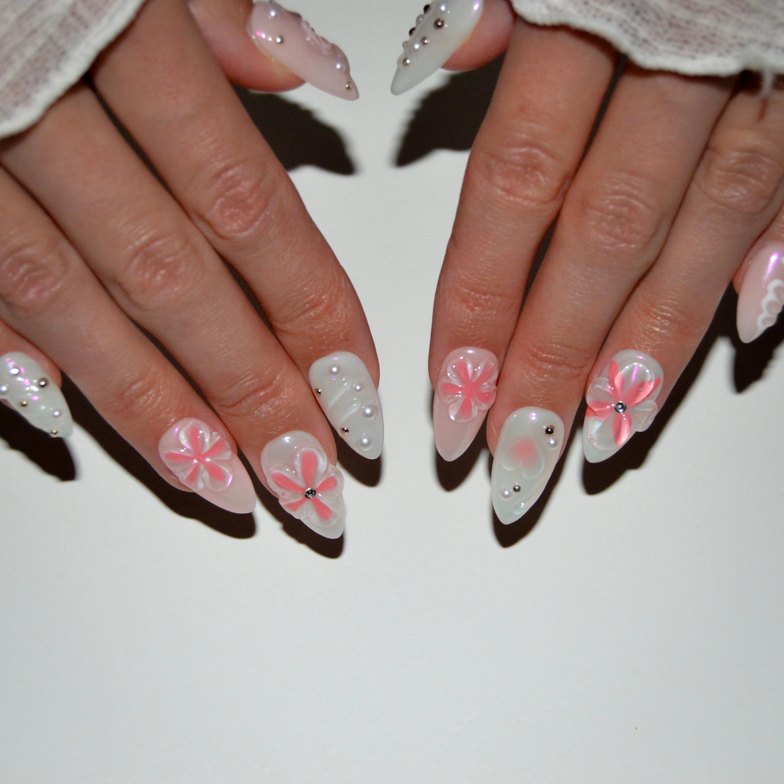 Press-on nails Pink Fever portés, décor rose et blanc avec perles et fleurs 3D, finition brillante, modèle fait main par Mimi Press-on.