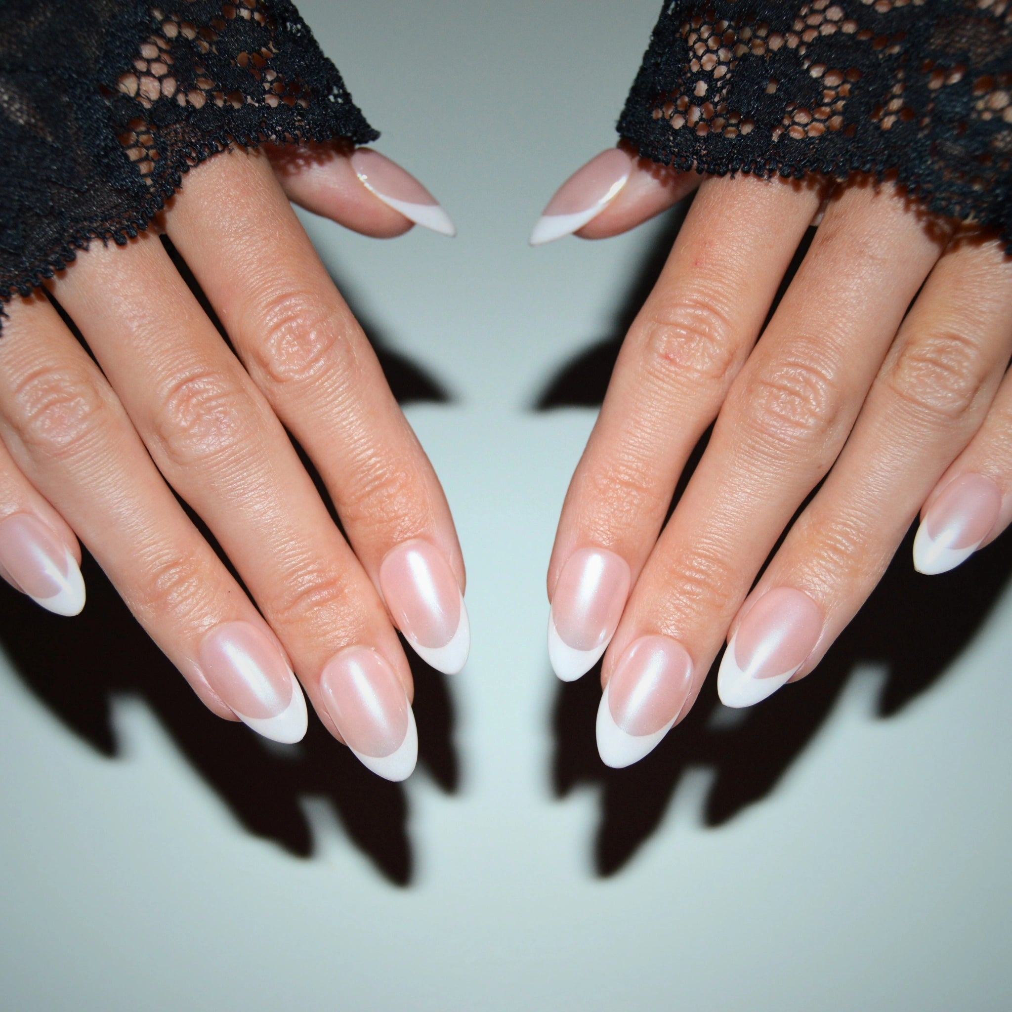 Vue d’ensemble des press-on Silky French portés sur deux mains, design french blanche sur base nude nacrée, fabrication à la main gel et acrylique.
