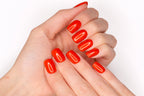 Faux ongles press-on Tangerine Glow portés sur la main — rouge orangé brillant sur ongles courts ronds — Mimi Press-On