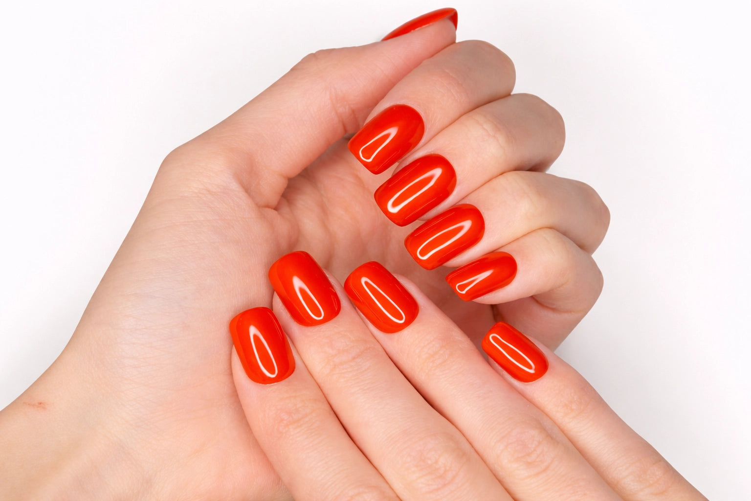 Faux ongles press-on Tangerine Glow portés sur la main — rouge orangé brillant sur ongles courts ronds — Mimi Press-On