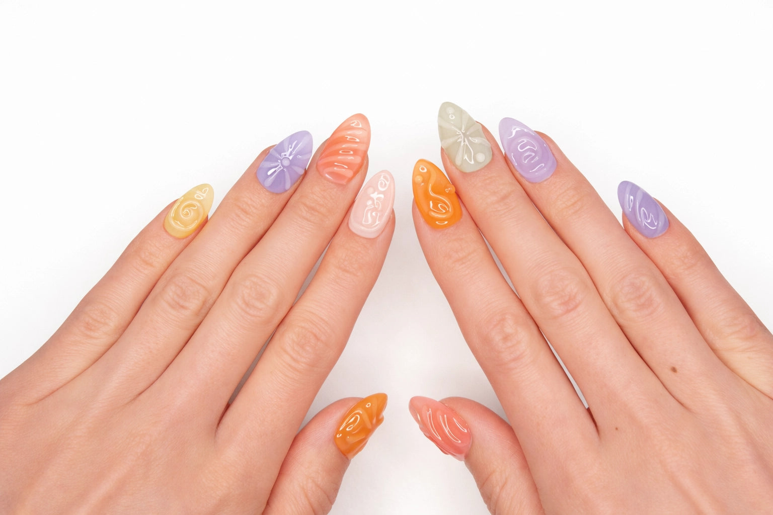 Faux ongles press-on Jelly Bean portés sur la main — textures 3D sculptées en pastel pêche lavande rose et bleu — Mimi Press-On