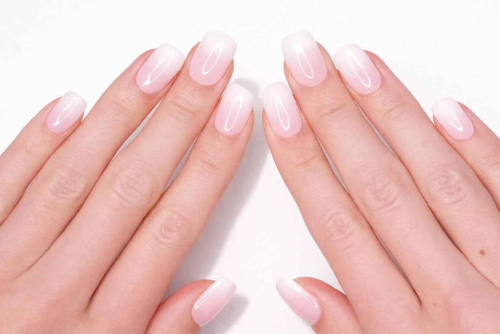 Faux ongles press-on baby boomer portés sur la main — dégradé rose poudré vers blanc naturel — Mimi Press-On