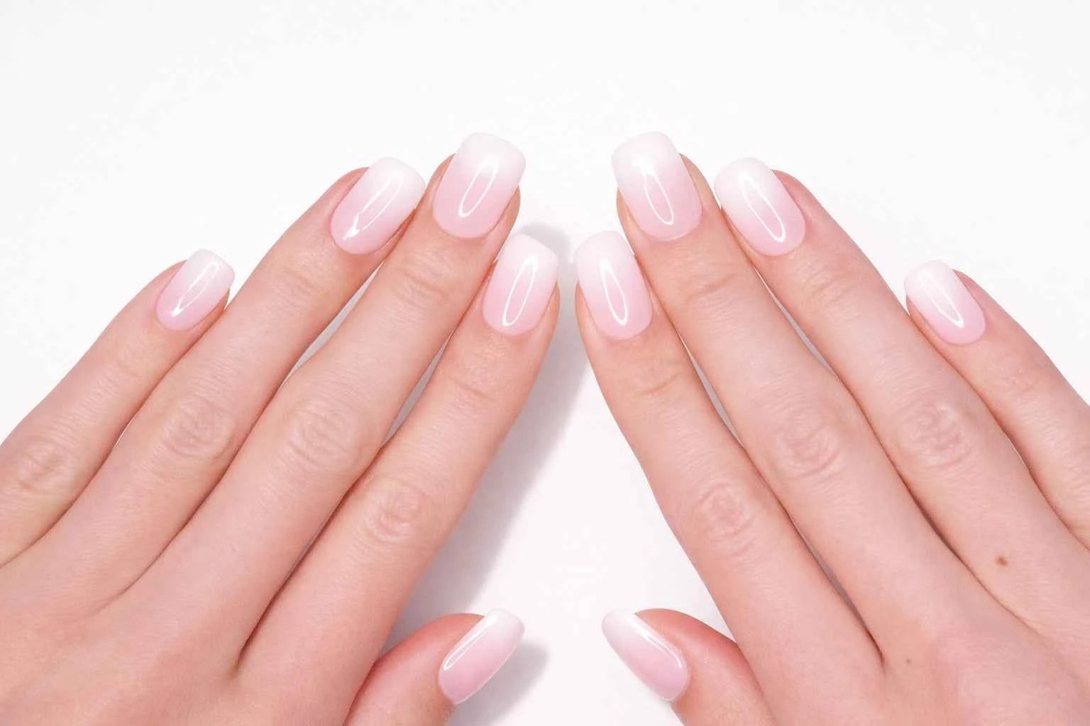 Faux ongles press-on baby boomer portés sur la main — dégradé rose poudré vers blanc naturel — Mimi Press-On