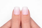 Gros plan sur le pouce avec faux ongle press-on baby boomer — fondu rose vers blanc laiteux — Mimi Press-On
