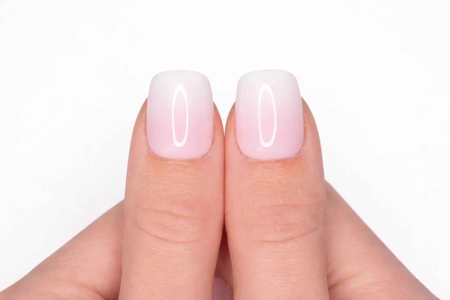 Gros plan sur le pouce avec faux ongle press-on baby boomer — fondu rose vers blanc laiteux — Mimi Press-On