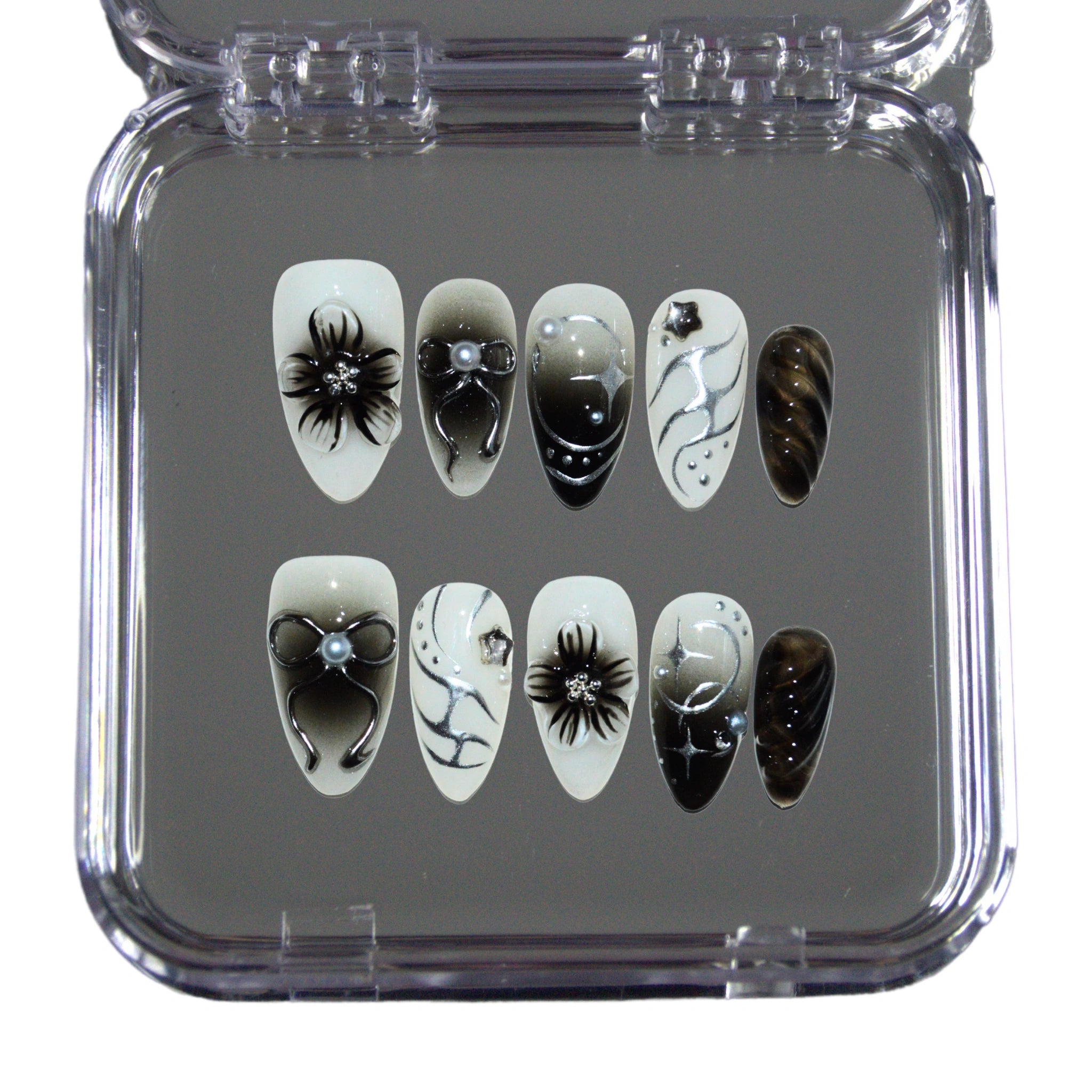 Boîte ouverte des press-on nails faits main Shadow Petal en gel et acrylique haut de gamme, design noir et blanc 3D avec fleurs, nœuds et détails brillants.