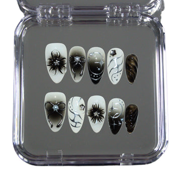 Boîte ouverte des press-on nails faits main Shadow Petal en gel et acrylique haut de gamme, design noir et blanc 3D avec fleurs, nœuds et détails brillants.