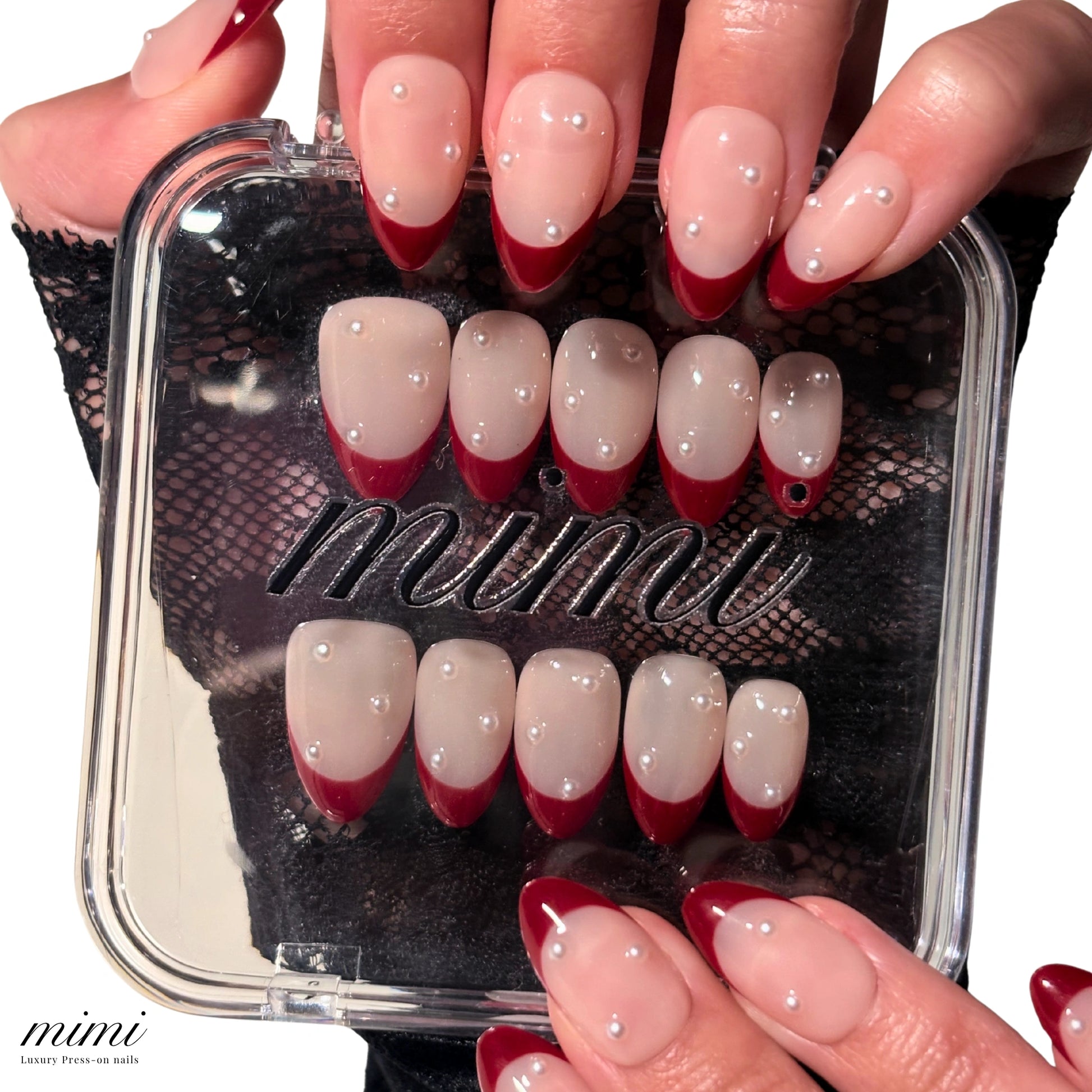 Boîte du set Holly Ruby Mimi tenue en main, press-on nails french rouge perlée en présentation, ongles faits main.