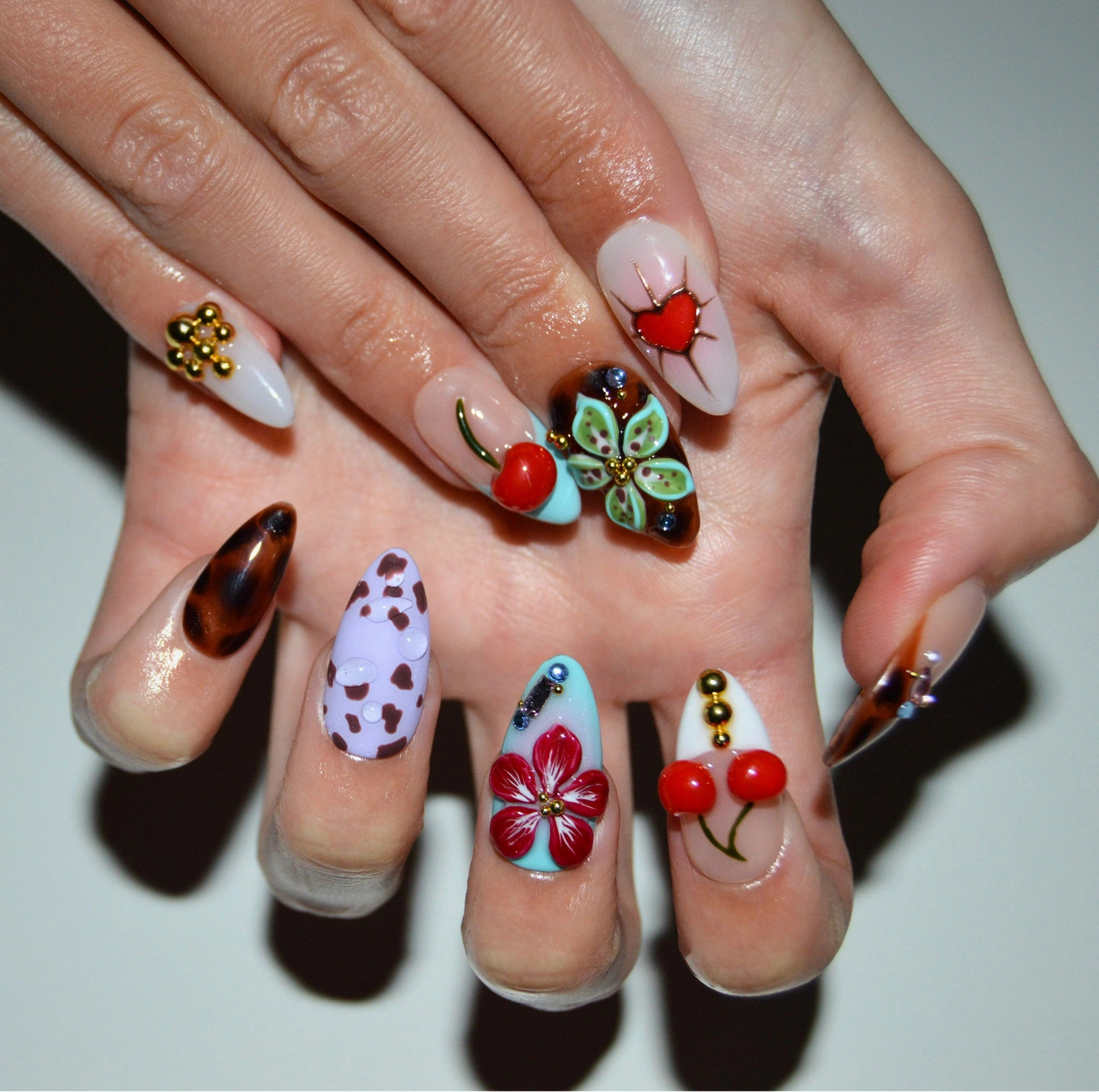 Press-on nails Trip to Vegas portés, designs artistiques 3D multicolores faits main, vue rapprochée des motifs Mimi France.