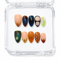 Press-on nails Wonderfall portés, motifs automnaux multicolores avec étoiles, pois et dégradés, rendu artistique Mimi France.